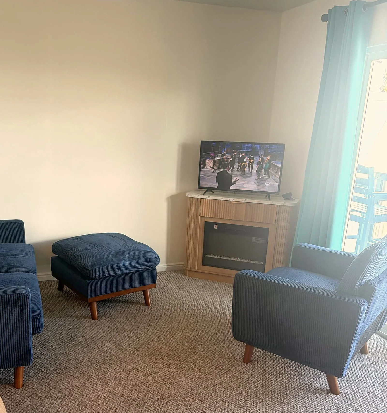 Living room with blue sofa, armchair and fireplace TV stand at Bear Lake Lookout