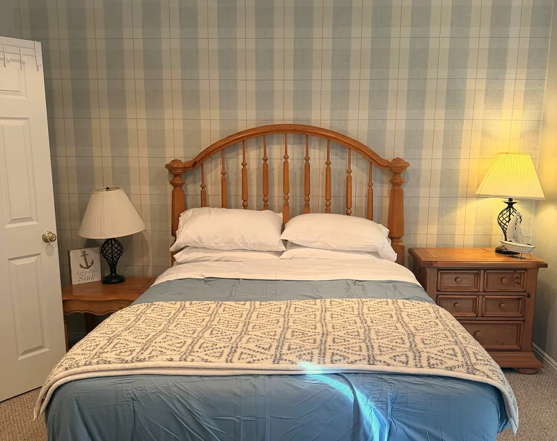 Bedroom with queen bed and blue plaid walls at Bear Lake Lookout